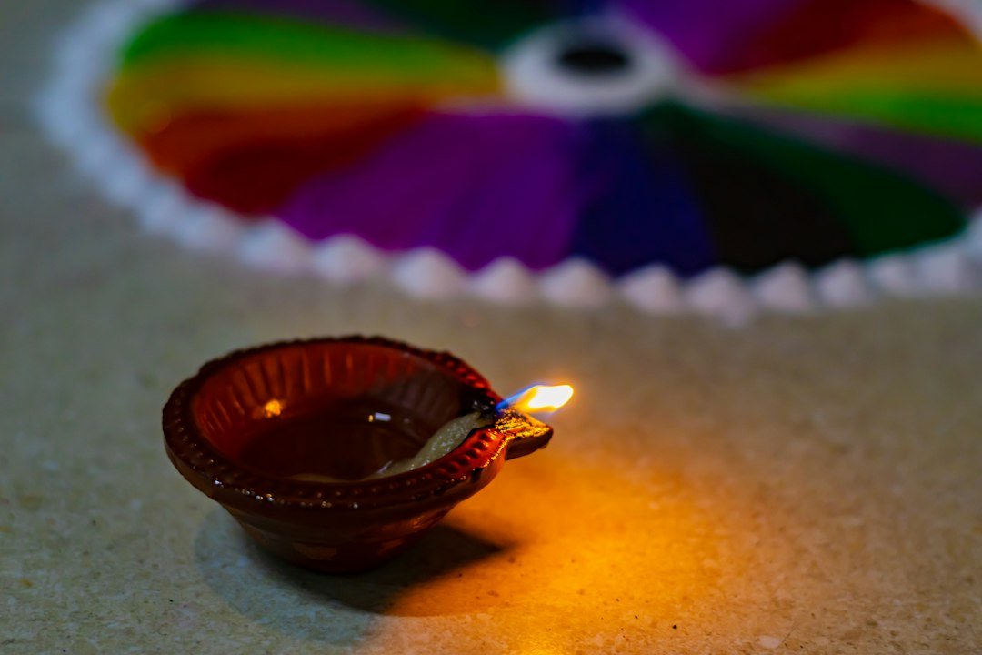 Colourful rangoli beside a diya for Diwali greetings 2026